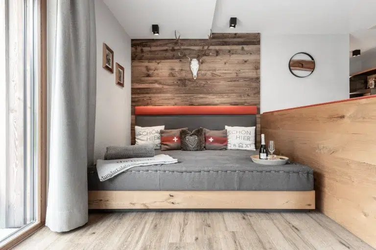 Gemütliches, modernes Schlafzimmer mit Holzakzenten, grauer Bettwäsche und Ferienwohnung Samnaun Dekor.