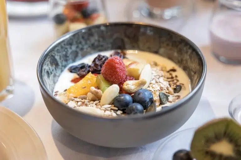 Eine Schale Joghurt mit Beeren, Nüssen und Samen steht auf dem Tisch des Ferienhauses Samnaun bereit.