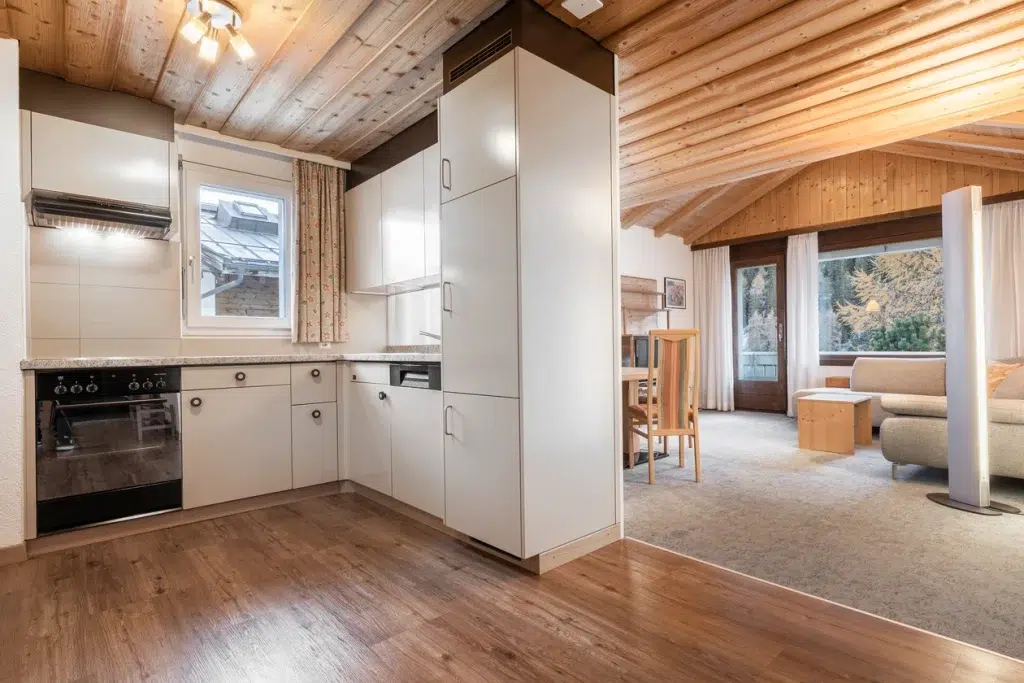 Moderne Küche mit Holzakzenten im Apartment Samnaun, offen zu einem gemütlichen Wohn- und Essbereich.