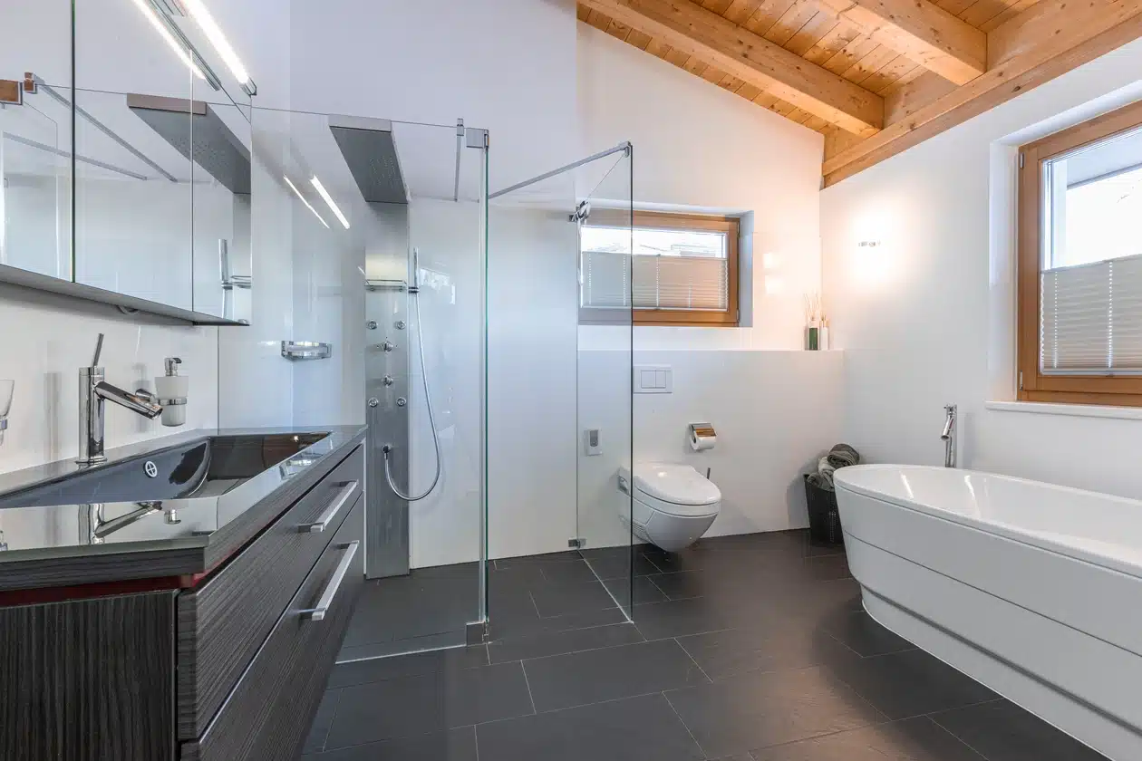 Modernes Badezimmer mit Glasdusche, freistehender Badewanne und Holzdeckenakzenten.